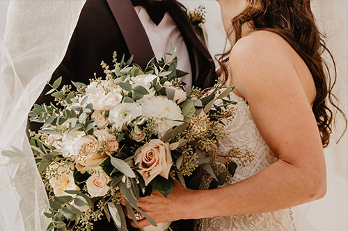 Bride and groom embracing with wedding bouquet – symbolic of UK spouse visa eligibility and marriage-based immigration support.